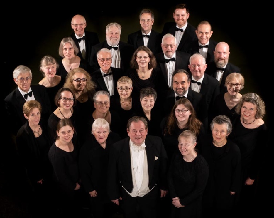 A formal picture of FCC members in concert dress surrounding their conductor